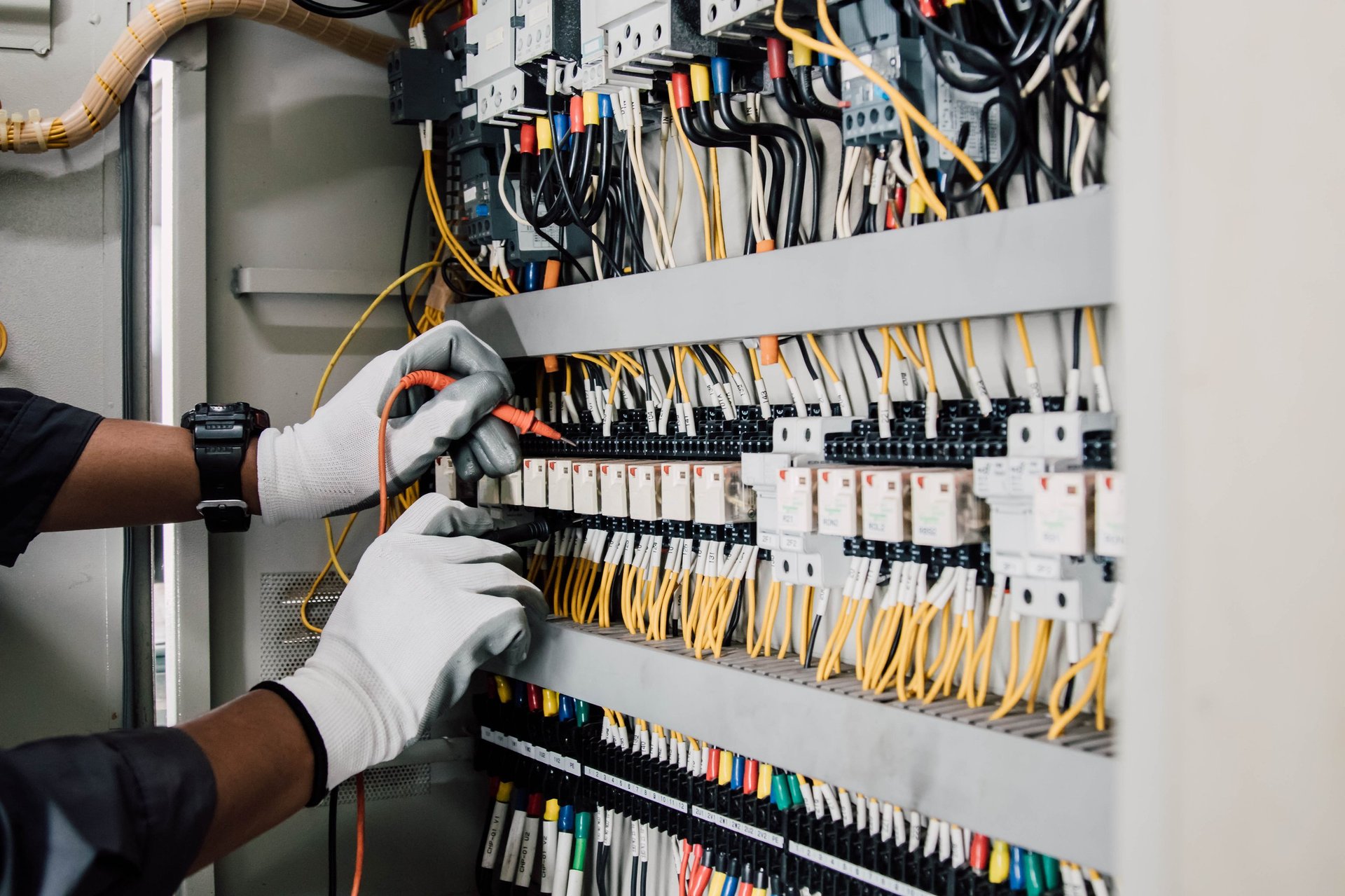Electrician engineer testing electrical installations and wires on relay protection system